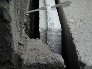 Colour Photograph of an External Cavity Wall, showing 'Floating' Thermal Insulation (and, in the background, an Inclined Steel Wall Tie which will later facilitate water ingress). Click to enlarge. Photograph taken by CJ Walsh. 2000-01-19.